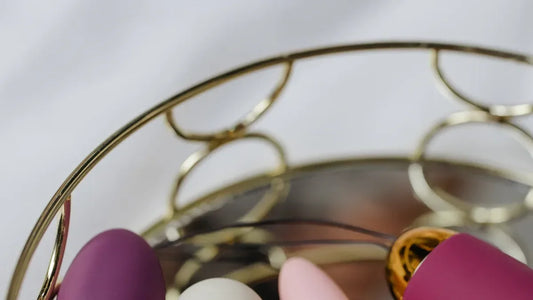 Purple and pink silicone vibrators in gold wire basket, luxury adult toys
