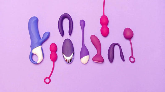 Assorted vibrators and adult toys in purple and pink on soft lavender background