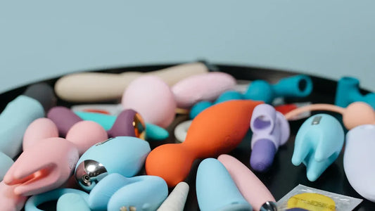 Colorful vibrators and adult toys displayed on black surface, featuring premium designs for intimate pleasure.