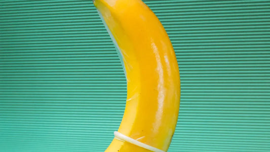 Yellow curved adult toy with white band against teal striped background