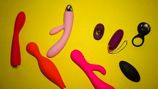 Colorful vibrators and adult toys on yellow background, including G-spot and clitoral designs